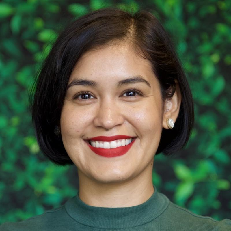A photo of Valeria Garcia wearing a green shirt with a green background.